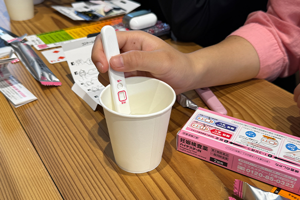 教材のハイテスターN(妊娠検査薬)で水を用いて終了線の確認をする生徒たち